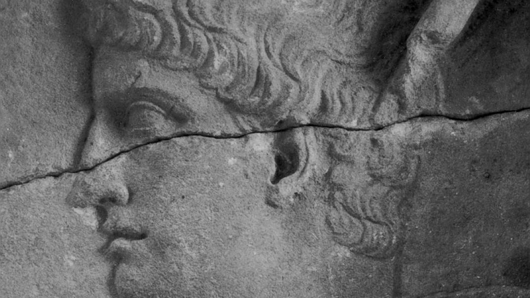Close up a face in relief on the puteoli marble block.