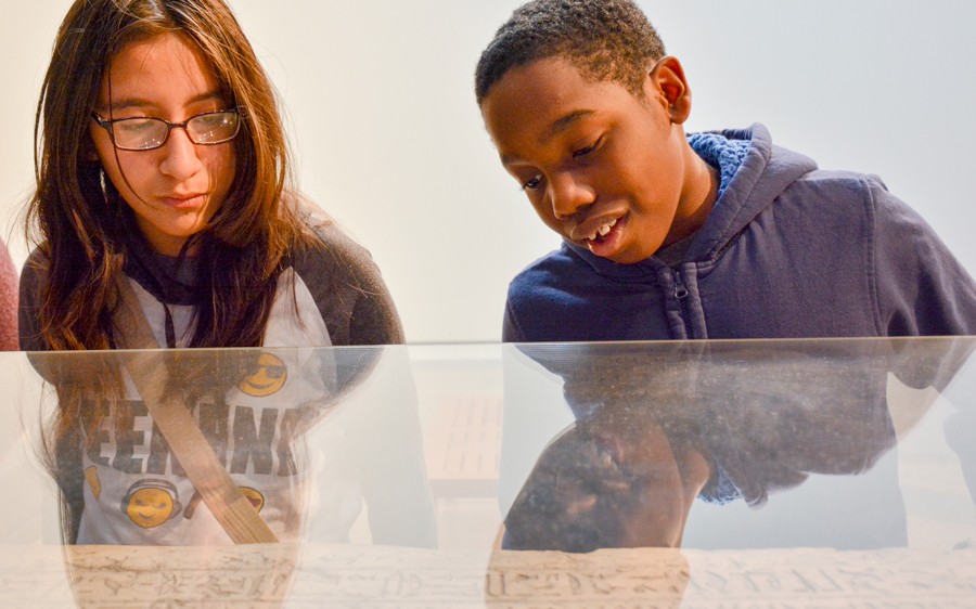 Two children admiring an Egyptian artifact.